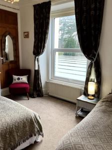 a bedroom with a bed and a large window at Charming, Cozy Apartment, 2 mins from the Beach in Llanfairfechan