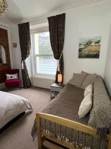 a bedroom with a bed and a window at Charming, Cozy Apartment, 2 mins from the Beach in Llanfairfechan