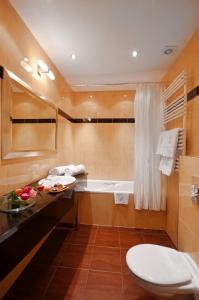 a bathroom with a toilet and a bath tub at Hotel Wolne Miasto Old Town Gdańsk in Gdańsk