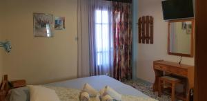 1 dormitorio con cama, espejo y piano en Iasonas Rooms en Agios Kirykos