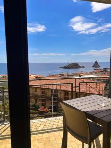 a balcony with a table and a view of the ocean at Hotel Lachea in Acitrezza