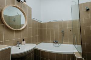 a bathroom with a tub and a sink and a mirror at Fritz Manor Bed and Breakfast in Swakopmund