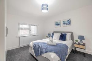 - une chambre avec un grand lit et une couverture bleue dans l'établissement 4BR Home Close to Slough Station, Private Driveway, à Canvey