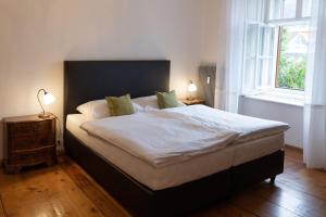 ein Schlafzimmer mit einem großen Bett mit weißer Bettwäsche und zwei Lampen in der Unterkunft Wohnen um die Jahrhundertwende in Brixen
