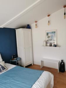 a bedroom with a bed and a white cabinet at Le Refuge de Manou in Saint-Péray