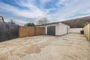 a parking lot with a garage and a fence at 4BR Home Close to Slough Station, Private Driveway in Canvey