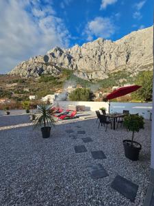 a patio with a table and chairs and a mountain at Apartman Koko with private jacuzzi in Makarska
