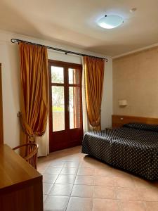 a bedroom with a bed and a large window at Hotel Lachea in Acitrezza