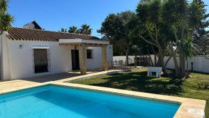 une villa avec une piscine et une maison dans l'établissement Vivienda Rural Atlántico Sur & Family, à Conil de la Frontera