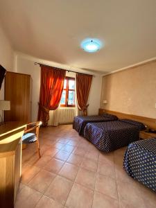a hotel room with two beds and a window at Hotel Lachea in Acitrezza