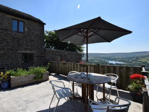 a table and chairs with an umbrella on a patio at 2 Bed in Whaley Bridge PK741 in Whaley Bridge