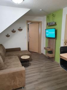 a living room with a couch and a flat screen tv at Fuchsbau Haasow 