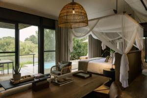 1 dormitorio con 1 cama y escritorio en una habitación en Zambezi Sands by Batoka, en Victoria Falls