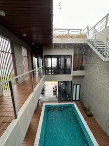 an indoor swimming pool in a building with a staircase at Villa AZJA PD in Port Dickson