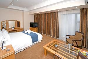Habitación de hotel con cama y TV en Orchids Lodge, en Fourways