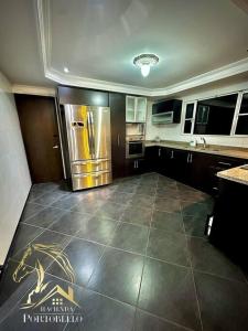 a kitchen with a refrigerator and a tile floor at Hacienda en Chia in Chía