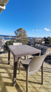 a table and a chair sitting on a balcony at Hotel Lachea in Acitrezza