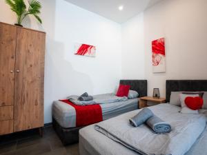 2 camas en una habitación con rojo y gris en SR24-Stillvolles gemütliches Apartment 3 in Recklinghausen, en Recklinghausen