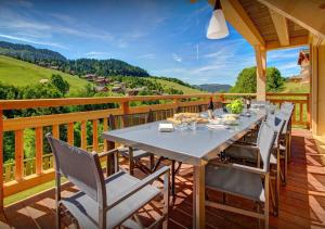 une terrasse en bois avec une table et des chaises dessus dans l'établissement Chalet Meringue - Les Congères, au Grand-Bornand