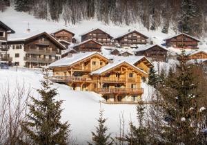 a large log cabin building in the snow at Chalet Meringue - Les Congères in Le Grand-Bornand
