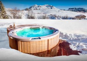 un jacuzzi dans la neige dans l'établissement Chalet Meringue - Les Congères, au Grand-Bornand