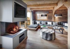 a living room with a couch and a fireplace at Chalet Meringue - Les Congères in Le Grand-Bornand