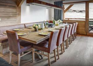 une salle à manger avec une longue table en bois et des chaises dans l'établissement Chalet Meringue - Les Congères, au Grand-Bornand 20 autres photos