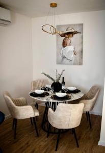 uma sala de jantar com uma mesa com cadeiras e um quadro em Apartman Star #2 em Vinkovci