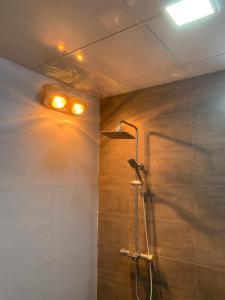 a bathroom with a shower with a light on the wall at Bảo An Home in Thái Nguyên