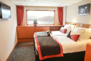 a hotel room with a bed and a window at Bateau Seine Princess by CroisiEurope in Paris
