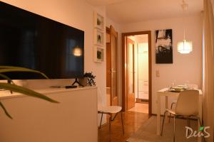 uma sala de estar com televisão e uma mesa com cadeiras em Ferienwohnung DEU5 em Bregenz