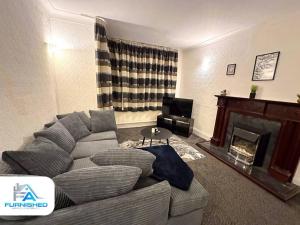 a living room with a couch and a fireplace at Large House - Relocation - Families in Manchester