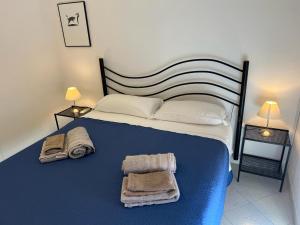 a bedroom with a large bed with towels on it at Mare Smeraldo Appartamento in Villasimius