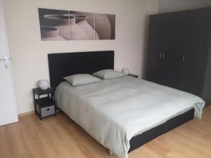 a bedroom with a large bed and a black cabinet at Basilique Corner in Brussels