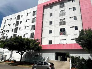 a pink and white building with a car parked in front at Apartamento Cerca al Rio y Complejo Deportivo in Valledupar