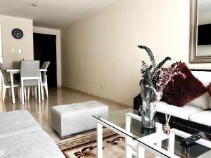 a living room with a vase of flowers on a glass table at Apartamento Cerca al Rio y Complejo Deportivo in Valledupar