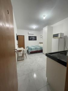 a room with a kitchen and a bedroom with a bed at Flat Completo Aparecida de Goiânia in Aparecida de Goiania