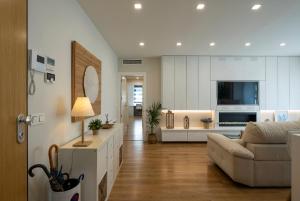 a living room with a couch and a tv at GUNI SUITES JARDINEs in Granada