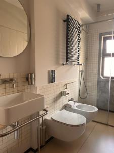 a bathroom with a sink and a toilet and a mirror at Hotel Lachea in Acitrezza
