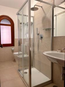a bathroom with a glass shower and a sink at Hotel Lachea in Acitrezza