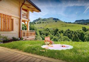 - une table de pique-nique dans l'herbe à côté d'une maison dans l'établissement Chalet Macaron - Les Congères, au Grand-Bornand