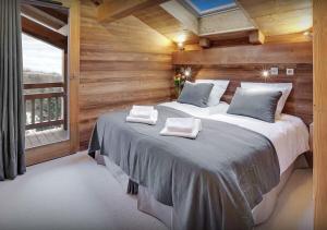 une chambre avec un grand lit et une fenêtre dans l'établissement Chalet Macaron - Les Congères, au Grand-Bornand 16 autres photos