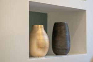 trois vases assis sur une étagère devant un miroir dans l'établissement Pgrhome Luxury Apartments Croce, à Rome