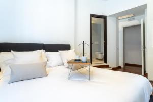 - une chambre avec un lit blanc et une table dans l'établissement Pgrhome Luxury Apartments Croce, à Rome