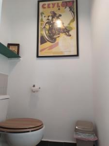a bathroom with a toilet and a poster on the wall at Las 3 Puertas 1 in Vejer de la Frontera