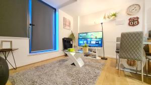 a living room with a desk and a tv and a window at Excellent 2 Bedroom City Centre Apartment in Sheffield