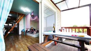 einen Balkon mit einem Tisch und einem Sofa auf einer Terrasse in der Unterkunft Jun Live Pension in Gangwha in Incheon