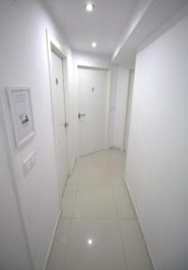 an empty hallway with white walls and white floors at Tus Habitaciones en Ruzafa in Valencia