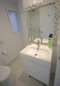 a white bathroom with a sink and a toilet at Tus Habitaciones en Ruzafa in Valencia