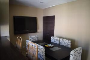 um quarto com uma mesa e cadeiras e uma televisão de ecrã plano em Duplex Jacaranda II em Ciudad Evita